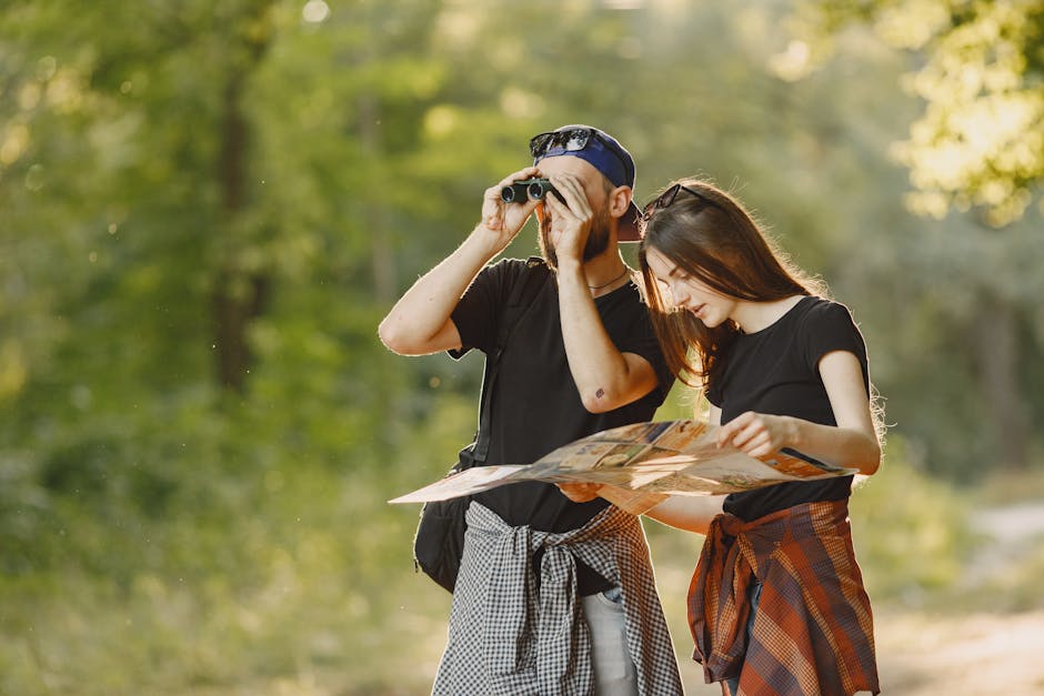 A couple outdoors using binoculars and a map for an adventure journey.